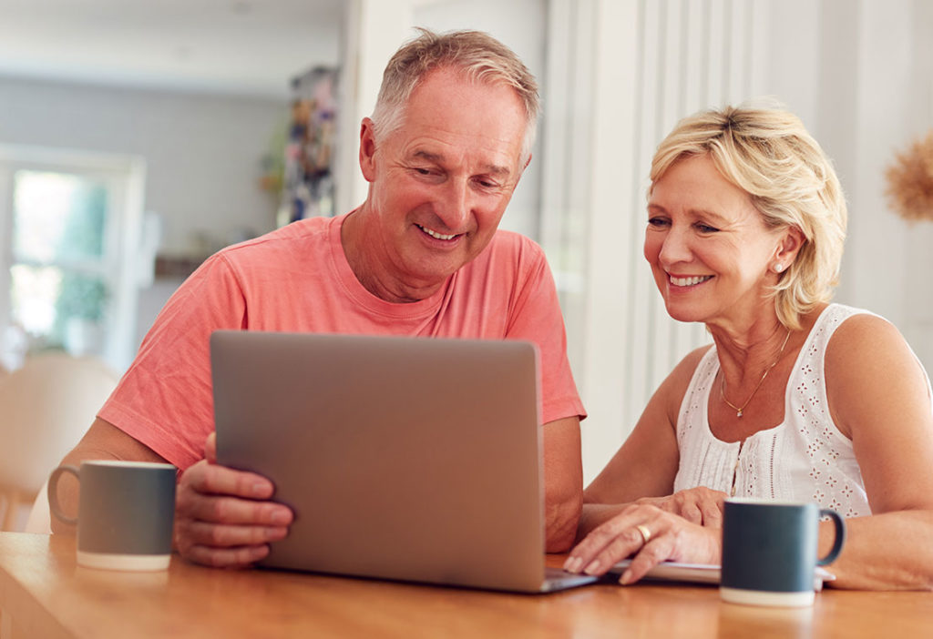 couple sitting at kitchen table looking at laptop benefits of an annuity loveland co
