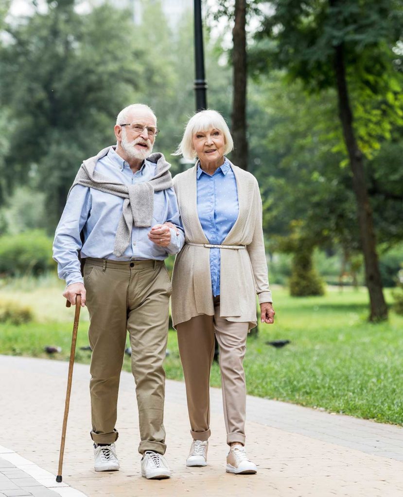 senior couple walking in park together reasonable rate of return during retirement loveland co
