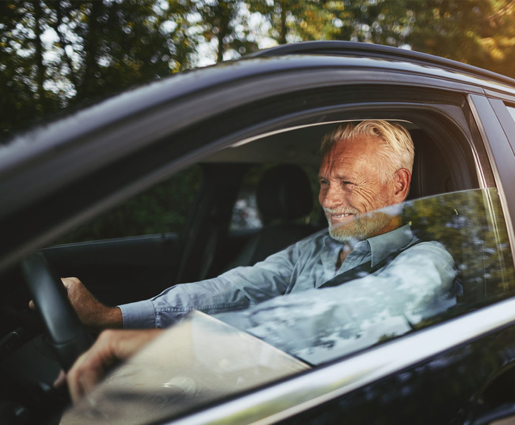 smiling senior man driving tax free retirement options loveland co